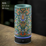 Decorative cylindrical object with floral patterns on a wooden surface
