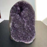 Amethyst crystal on a dark surface with a blurred background