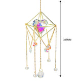 Decorative hanging crystal with gold frame and chains on a white background