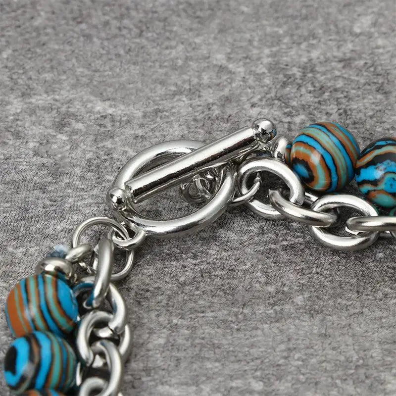 Bracelet with blue and brown striped beads on a gray background