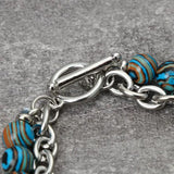 Bracelet with blue and brown striped beads on a gray background