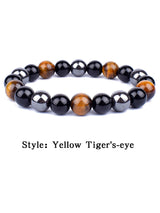 Beaded bracelet with yellow tiger's-eye and black beads on a white background