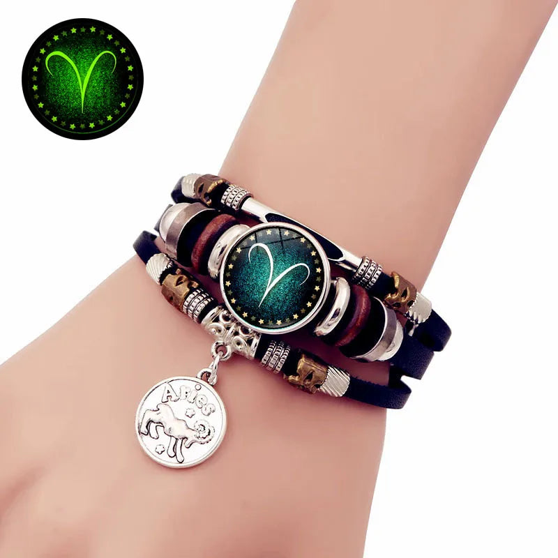Multistrand bracelet with a zodiac charm on a wrist, glowing in the dark.