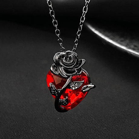 Necklace with a red gemstone and rose design on a dark background