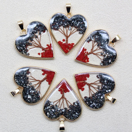 Heart-shaped pendants with nature-themed designs on a light gray background