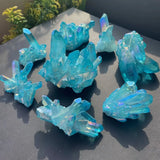 Collection of blue crystal formations on a dark surface with greenery in the background