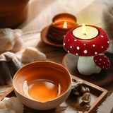 Tea cup with a mushroom-shaped candle holder on a soft fabric background