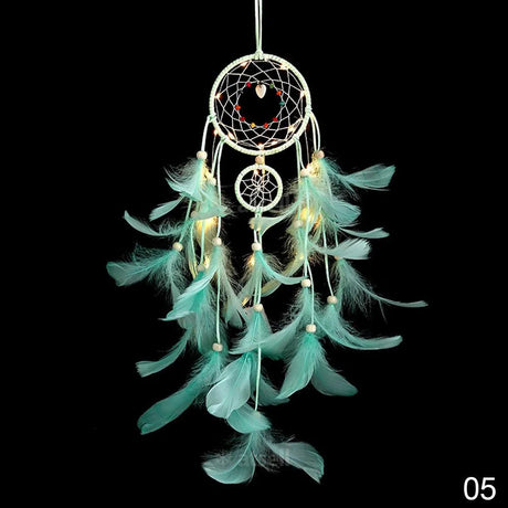 Turquoise feather dreamcatcher with lights on a black background