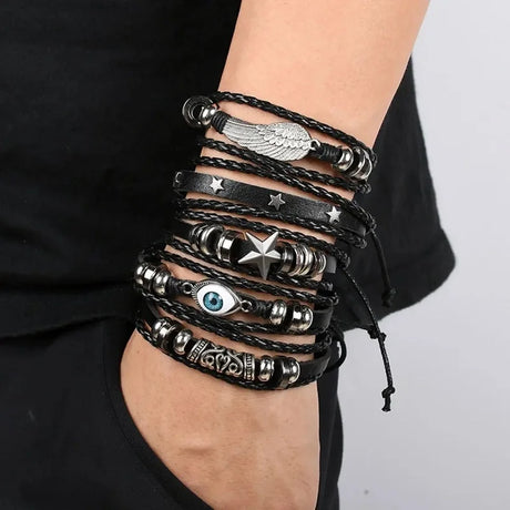Multiple black and silver bracelets on a wrist against a neutral background