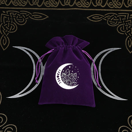 Purple drawstring bag with a white moon and crystal design on a black background with Celtic patterns.