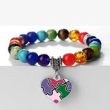 Colorful beaded bracelet with a heart-shaped puzzle piece charm on a white background