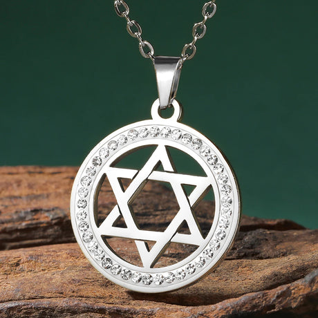 Silver pendant with Star of David design on a wooden surface