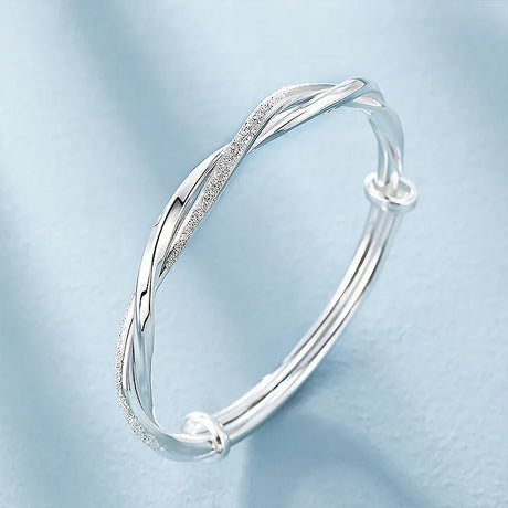 Silver bracelet on a light blue background