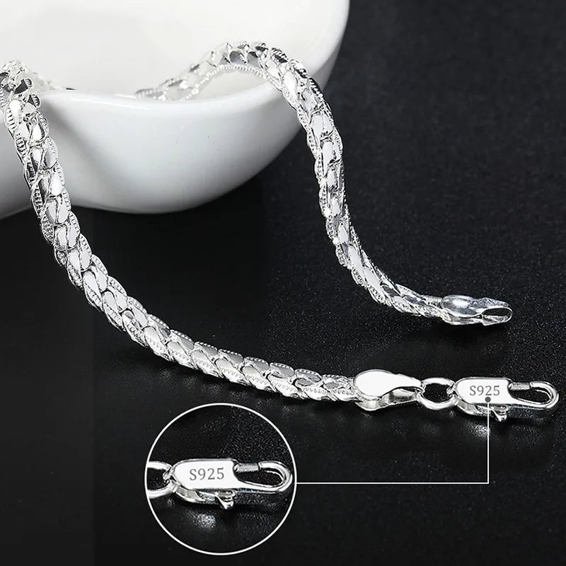 Silver bracelet with a close-up of the clasp on a dark surface