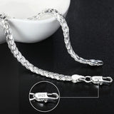 Silver bracelet with a close-up of the clasp on a dark surface