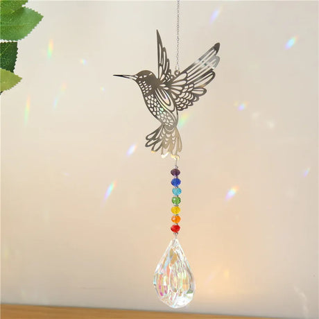 Decorative hanging ornament with a hummingbird design and rainbow beads on a light background
