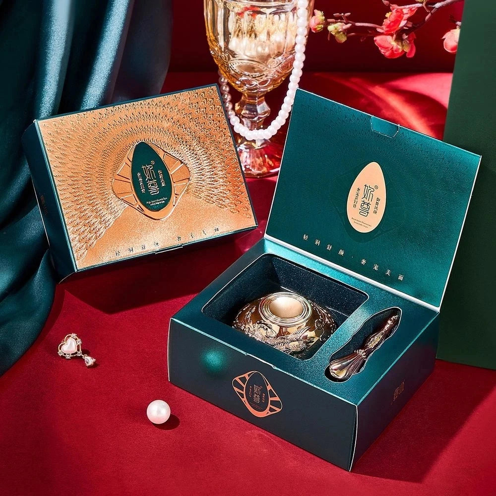 Decorative items including a crystal ball, earrings, and a box on a red surface with a green curtain.