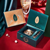Decorative items including a crystal ball, earrings, and a box on a red surface with a green curtain.