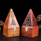 Two wooden pyramid-shaped incense burners with intricate designs on a dark background.