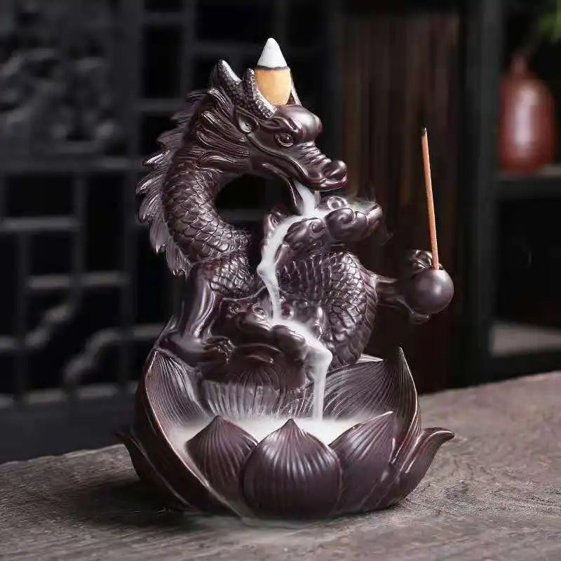 Dragon-shaped incense burner with incense sticks on a dark surface