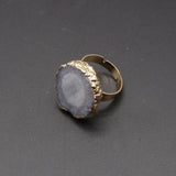 Ring with gold band and gray stone on a dark gray background