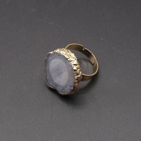 Ring with gold band and gray stone on a dark gray background