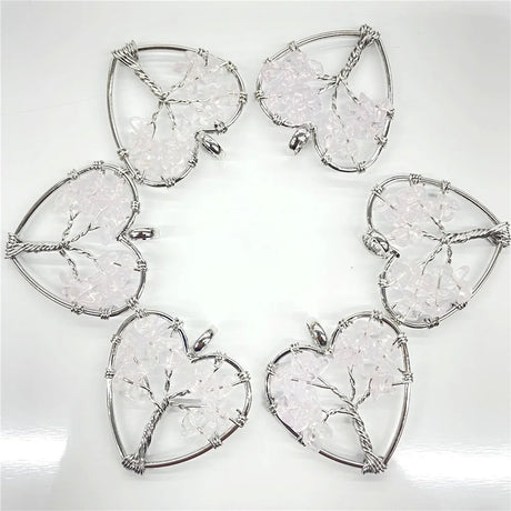 Heart-shaped silver pendants with clear gemstones on a white background