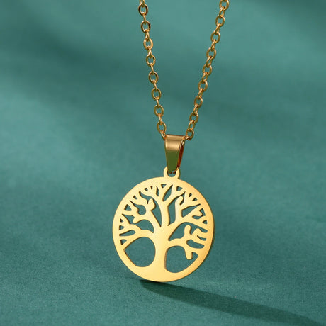 Gold tree-shaped pendant necklace on a green background
