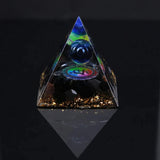 Triangular crystal pyramid with embedded eye design on a black background