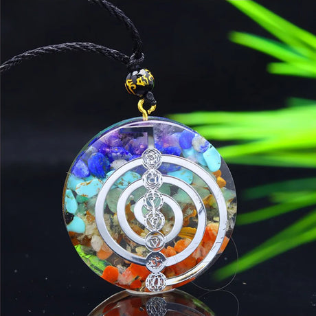Multicolored circular pendant with silver design on a black background