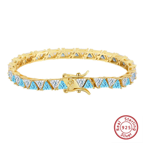 Gold bracelet with blue and clear gemstones on a white background, featuring a 'Real Sterling Silver' stamp.