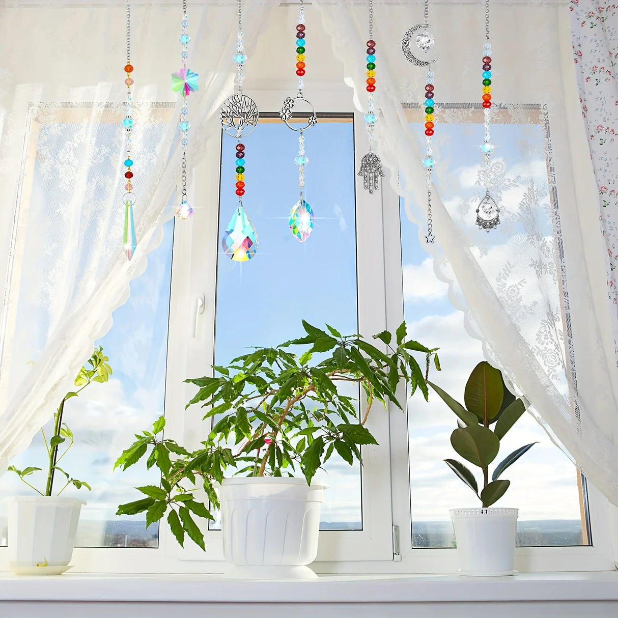 Decorative hanging crystals with colorful beads in front of a window with plants on the sill.