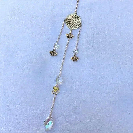 Delicate necklace with floral and bee designs on a light blue background