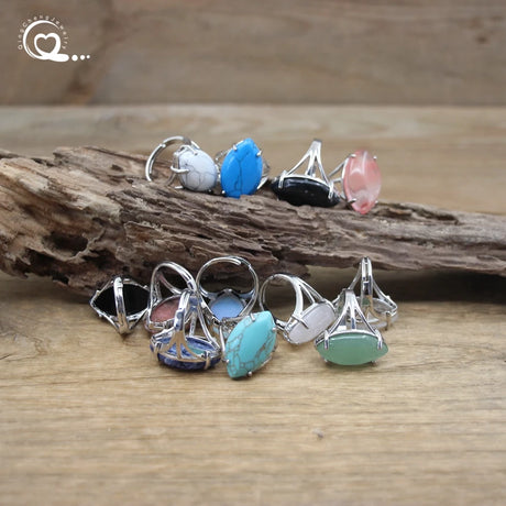 Set of silver rings with colorful gemstones on a wooden surface