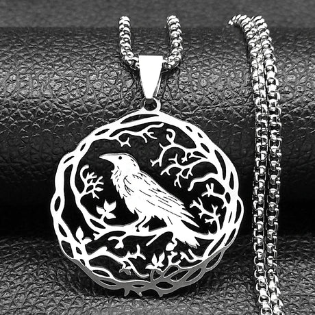 Silver pendant with bird design on a textured black surface