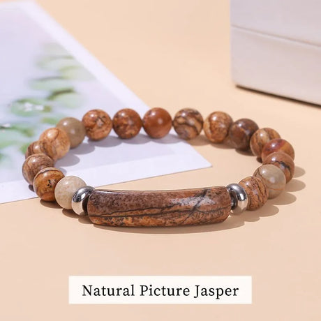 Beaded bracelet with natural picture jasper stones on a beige surface