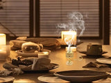 Candlelit dinner table with smoke rising from a candle, blurred background