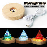 Wooden light base with USB cable and three pyramid-shaped lights on a white background
