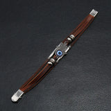 Decorative knife with brown handle and silver blade on a dark textured surface