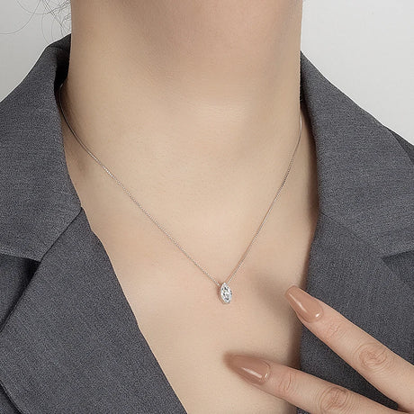 Necklace with a pendant worn by a person, against a neutral background