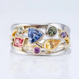 Multicolored gemstone ring on a light gray background