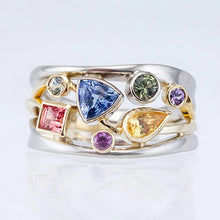 Multicolored gemstone ring on a light gray background