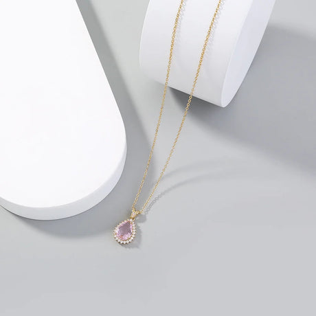 Necklace with a pink teardrop pendant on a light gray background
