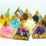 Colorful pyramid-shaped objects with embedded stones and crystals on a white background