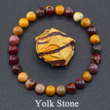 Round arrangement of marbled beads with a central yellow stone on a dark background, labeled 'Yolk Stone'.