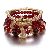 Stack of red beaded bracelets with gold accents on a white background
