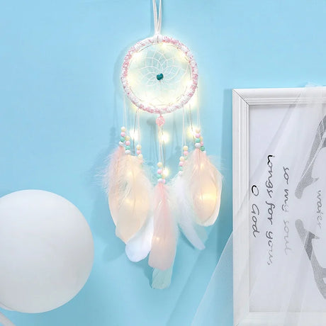 Decorative dreamcatcher with lights on a light blue wall.