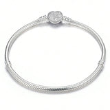 Silver bracelet with a textured design on a white background