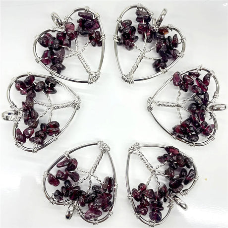 Six silver pendants with purple gemstones on a white background