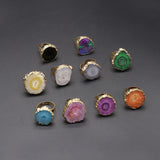 Collection of colorful rings with gold bands on a gray background